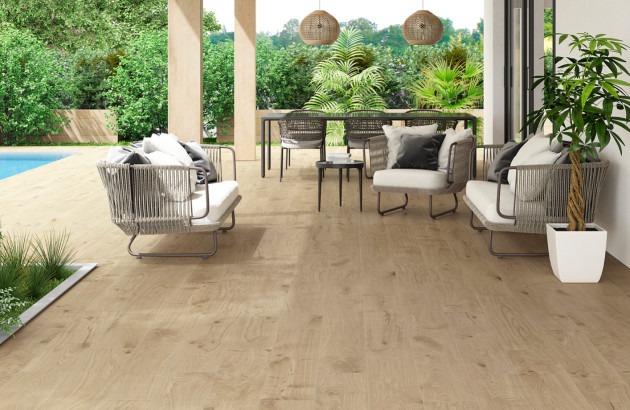 Terrasse couverte aménagée avec carrelage effet bois et mobilier extérieur contemporain.