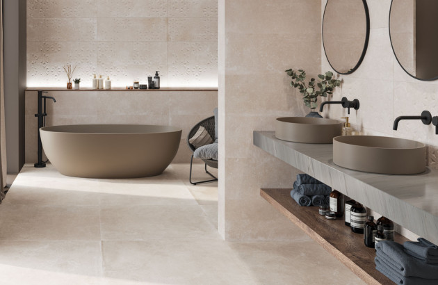 Salle de bains beige contemporaine avec baignoire îlot mate, double vasque et carrelage effet pierre apaisant.