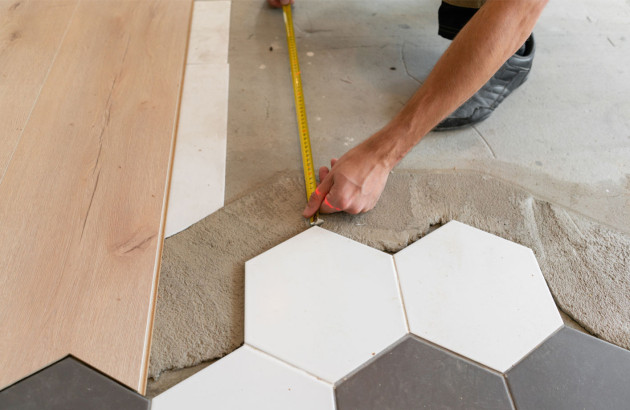 Homme qui mesure la surface de pose de carrelage