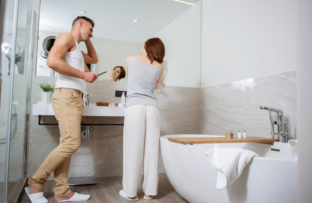 Couple qui effectue sa toilette matinale dans la salle de bains