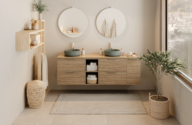 Meuble double vasque suspendu en bois avec deux vasques vertes et deux miroirs ronds.