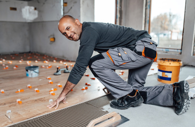 Carreleur en train de poser du parquet