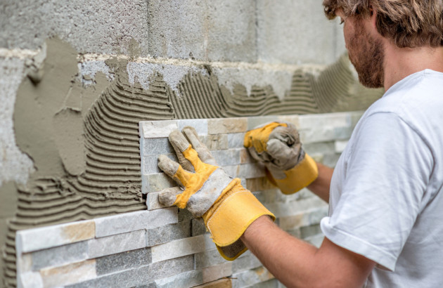Carreleur en train de poser un mur d'accent
