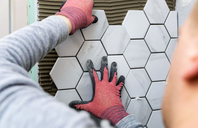 Carreleur qui pose des carreaux hexagonaux