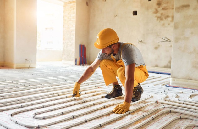 Professionnel en train d'installer le plancher chauffant