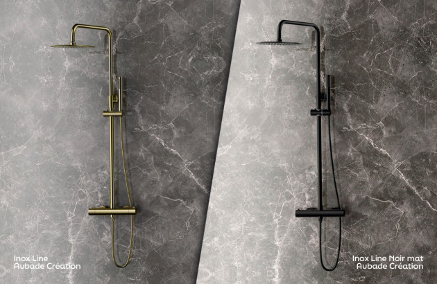 Deux colonnes de douche noire et dorée sur mur gris