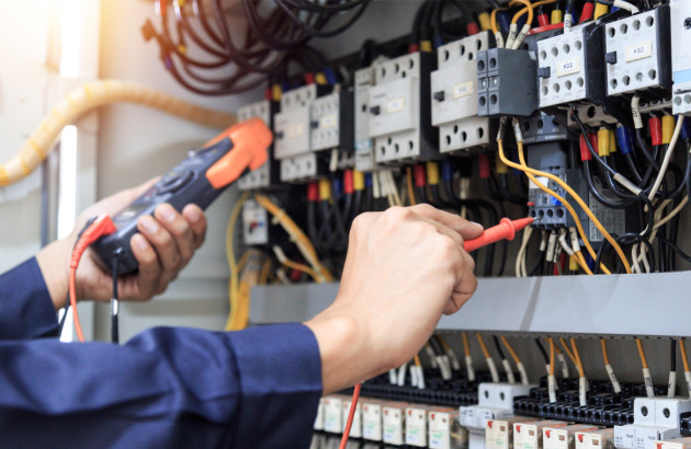 Électricien en train d'intervenir sur les disjoncteurs d'un immeuble