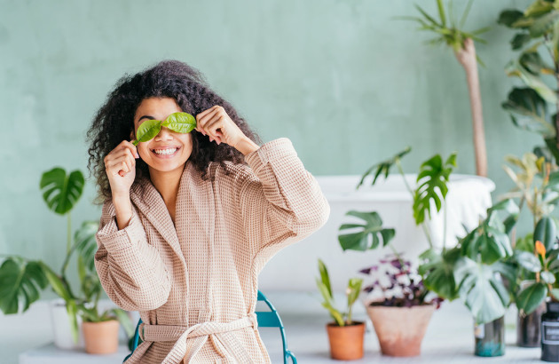 Femme devant ses plantes dans la salle de bains