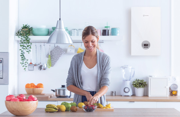 Femme préparant à manger dans une cuisine équipée d'une chaudière