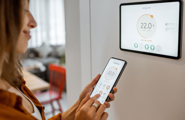 Femme qui contrôle la température de son foyer via son smartphone