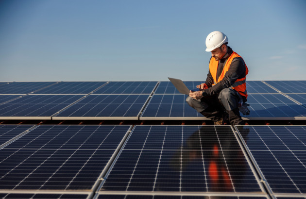 Homme réalisant l'entretien d'un panneau solaire