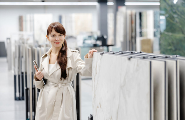 Jeune femme en train d'examiner du carrelage dans un showroom