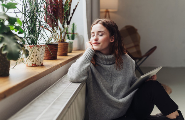 Jeune femme posée devant son chauffage 