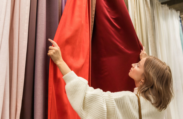 Une jeune femme qui examine un rideau thermique rouge
