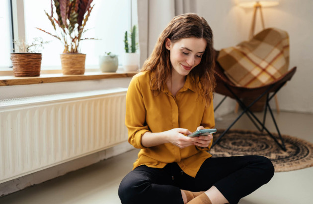 Jeune femme assise devant son radiateur