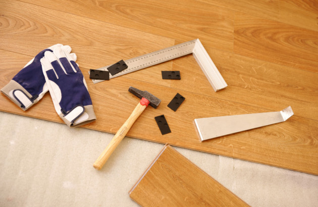 Outils de carreleur sur du parquet flottant