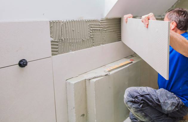 professionnel en train de poser des carrelages muraux