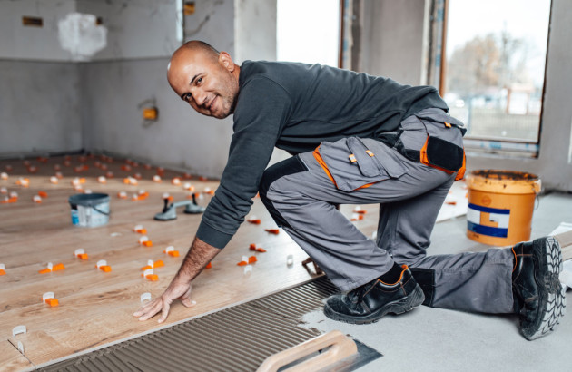 Professionnel en train de poser du carrelage effet parquet