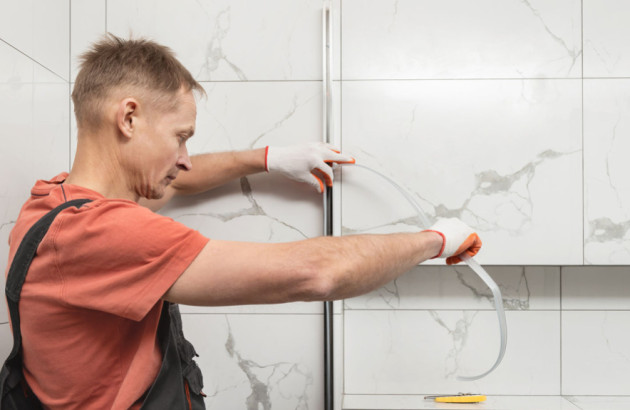 Professionnel installant les joint d'une porte de douche