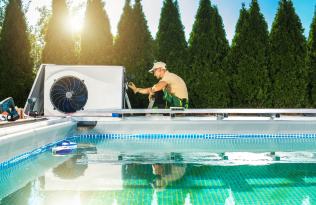 Un professionnel en train d'installer une pompe à chaleur pour piscine
