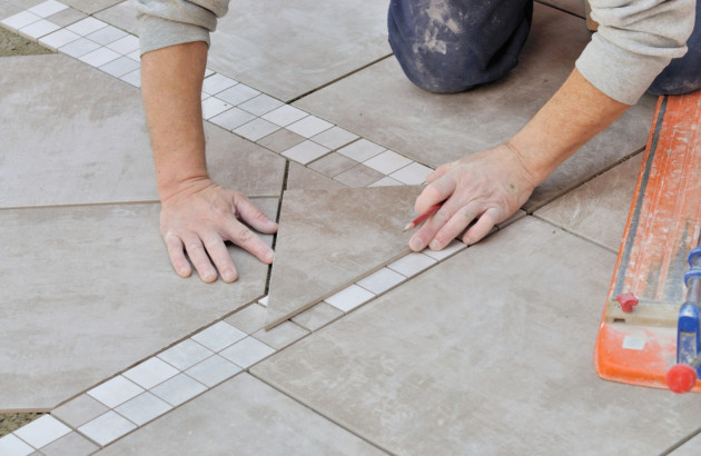 Professionnel posant du carrelage beige
