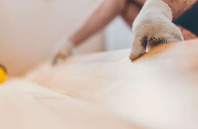 Professionnel qui installe du parquet flottant