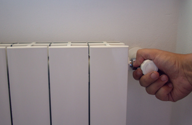 Purge radiateur : main actionne vanne pour dégazage chauffage.