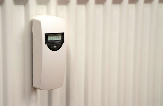 Répartiteur de frais de chauffage fixé sur un radiateur blanc à panneaux verticaux