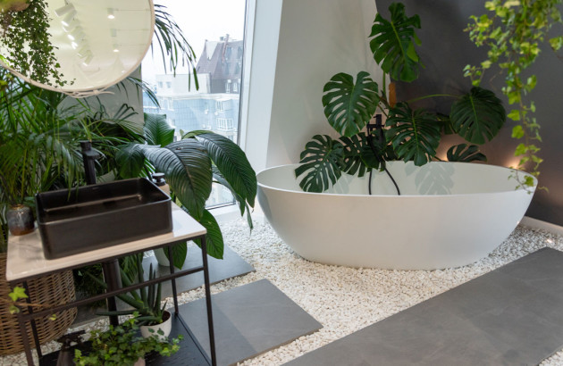Salle de bains moderne avec baignoire et des plantes autour