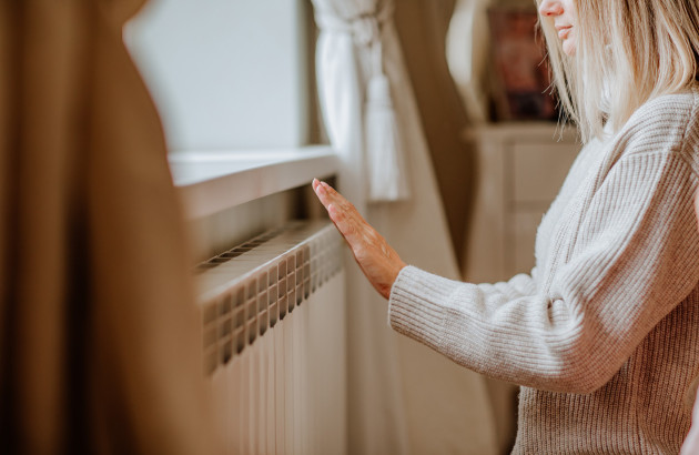 Femme qui place sa main proche d'un radiateur
