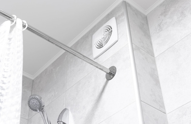Bouche d'aération positionnée au dessus d'une douche dans une salle de bains