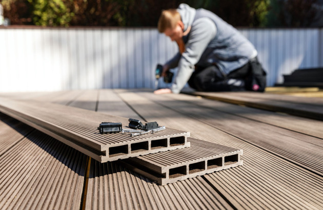 Personne qui installe un plancher en bois composite