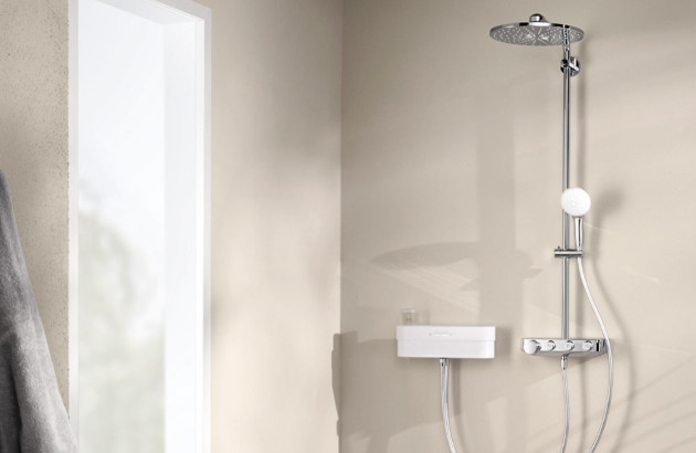 Colonne de douche thermostatique chromée avec douche de tête extra-plate dans une salle de bains épurée.