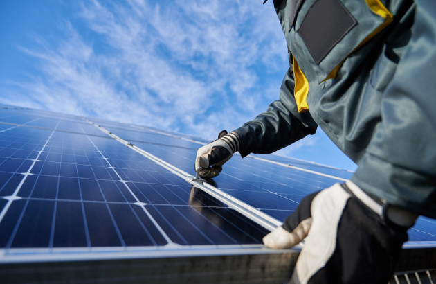 Artisan qui installe un kit de panneaux photovoltaïques