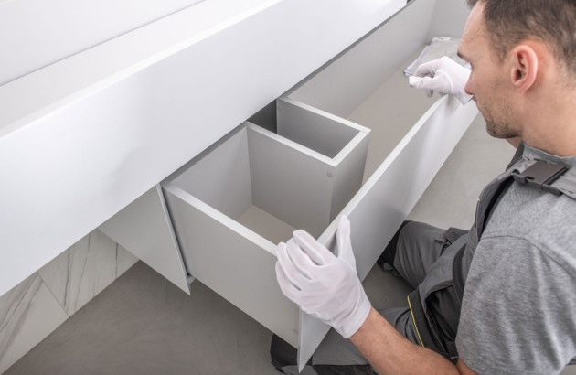 Homme qui installe un meuble de salle de bains