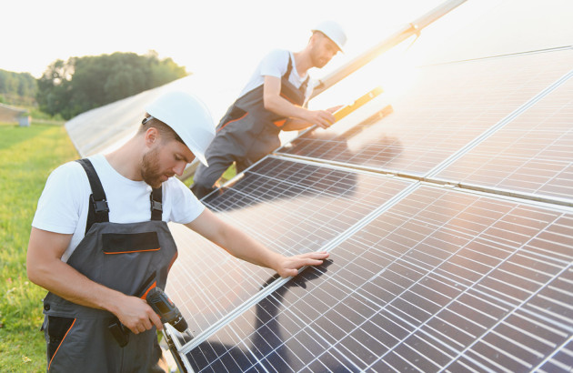 Ouvriers qui installent des panneaux solaires bifaciaux
