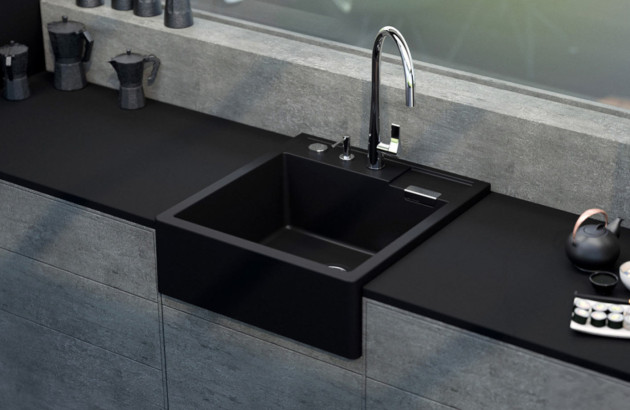 Évier timbre d’office noir encastré dans un plan de travail sombre pour une cuisine moderne au design minimaliste.