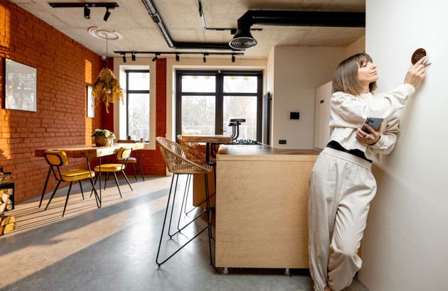 Femme qui utilise une solution intelligente intégrée à sa maison