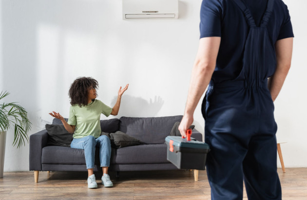 Femme qui explique son problème de climatisation à un artisan