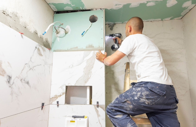 Professionnel qui réalise des travaux d'isolation dans la salle de bains