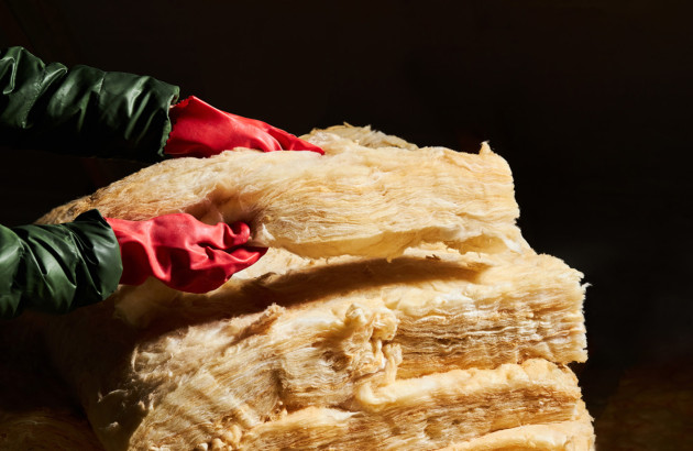 Personne equipée de gants qui manipule un matériau isolant