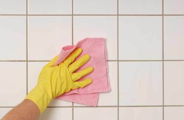 Personne qui passe le chiffon sur des joints de carrelage en mortier ciment
