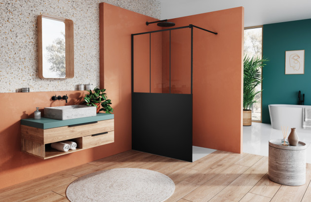 Douche à l’italienne équipée d’une paroi noire, dans une salle de bains aux tons orange