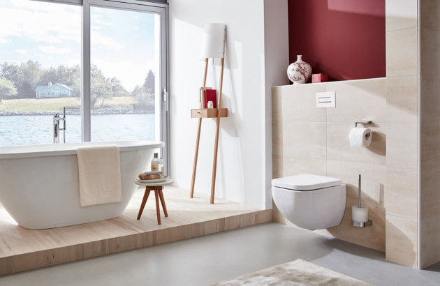 Salle de bains contemporaine avec WC suspendu blanc, baignoire et carrelage mural beige.