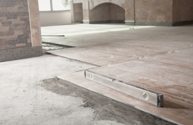 Pose de carreaux de carrelage XXL dans un bâtiment en pierre