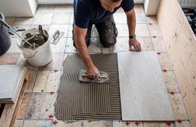 Application du mortier-colle lors d’une rénovation de sol carrelé