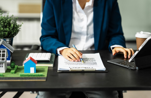 Personne en tenue de travail de bureau qui évalue un document