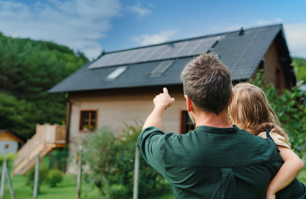 Famille devant une maison alimentée par l’énergie solaire