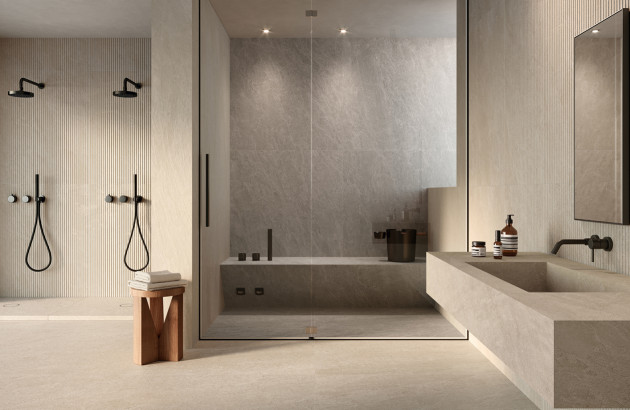 Salle de bains contemporaine avec double douche ouverte, baignoire intégrée et vasque suspendue en pierre.