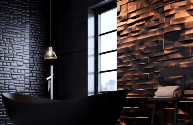 Salle de bains sombre avec baignoire noire et mur en zellige noir texturé, éclairage chaud.